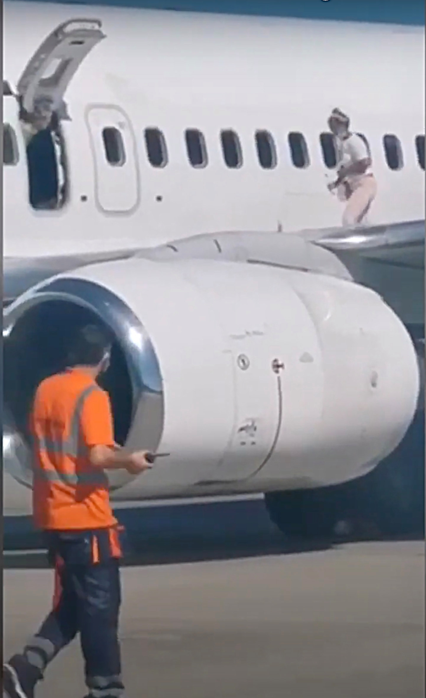Mulher caminha pela asa do avião depois de reclamar de calor