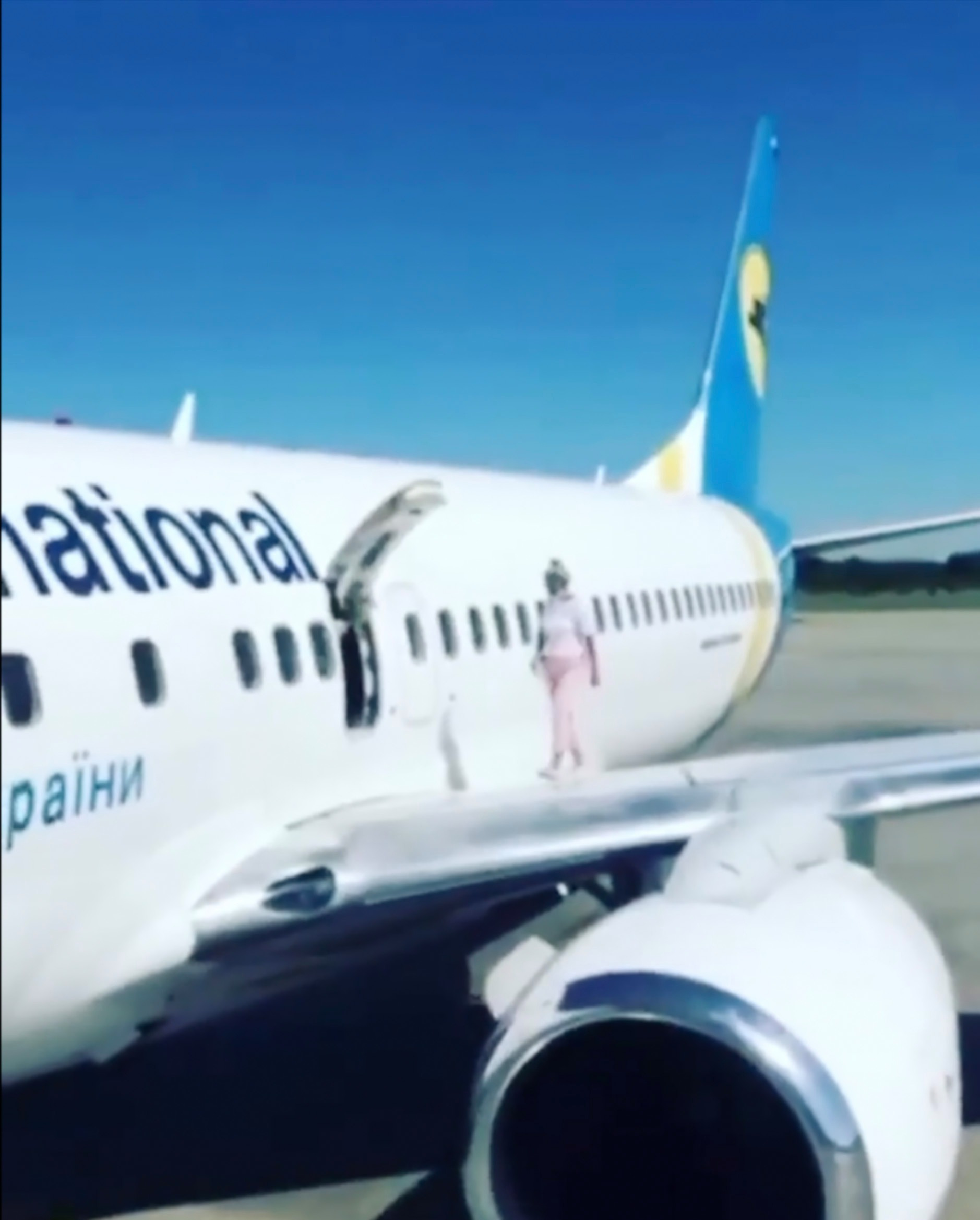 Mulher caminha pela asa do avião depois de reclamar de calor